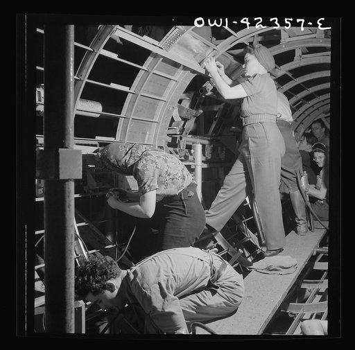 Untitled photo, possibly related to: Boeing aircraft plant, Seattle, Washington. Production of B-17F (Flying Fortress) bombing planes. A crew working in a nearly completed fuselage section