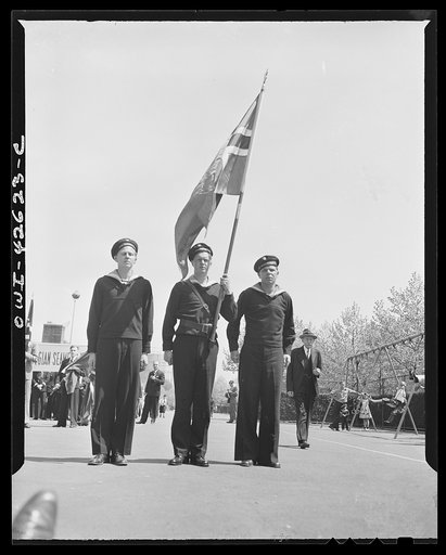 Brooklyn, New York. Norwegian Independence Day celebration. Norwegian-American parade. Jens Jensen, office representative of the Norwegian Seamen's Union, between two navy men. In the background is the building of the Norwegian Seamen's Association
