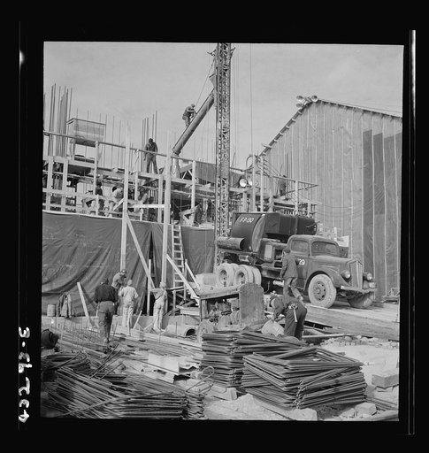 Untitled photo, possibly related to: Columbia Steel Company at Geneva, Utah. Setting a pipe with a derrick during the construction of a new steel mill which will make important additions to the vast amount of steel needed for the war effort
