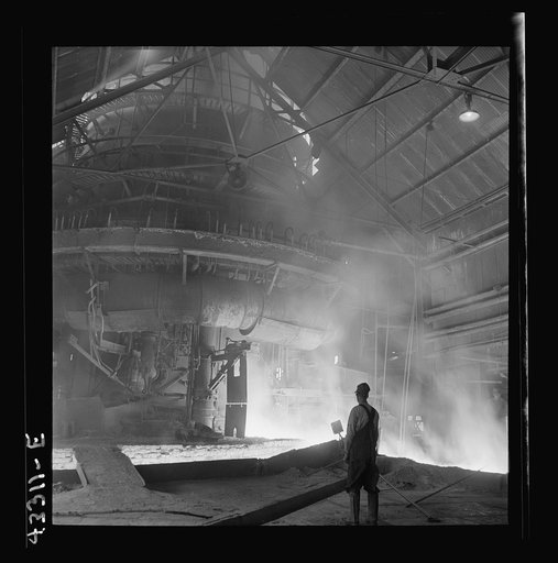 Columbia Steel Company at Ironton, Utah. Tapping a heat of iron in the cast house of the blast furnace