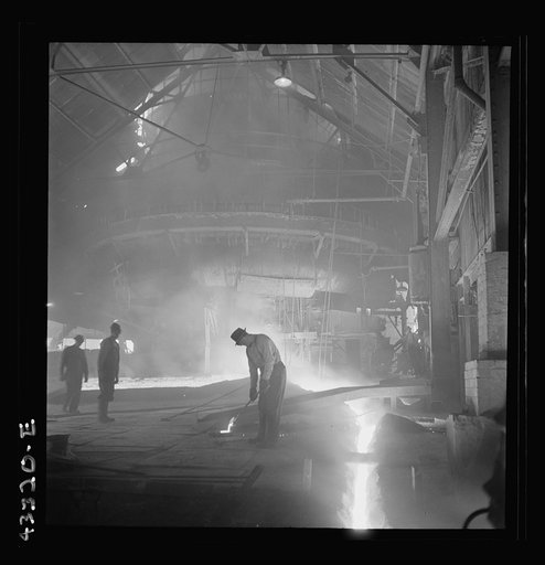 Columbia Steel Company at Ironton, Utah. Tapping a heat of iron in the cast house of the blast furnace