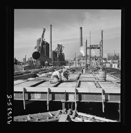 Untitled photo, possibly related to: Columbia Steel Company at Geneva, Utah. Setting a pipe with a derrick during the construction of a new steel mill which will make important additions to the vast amount of steel needed for the war effort