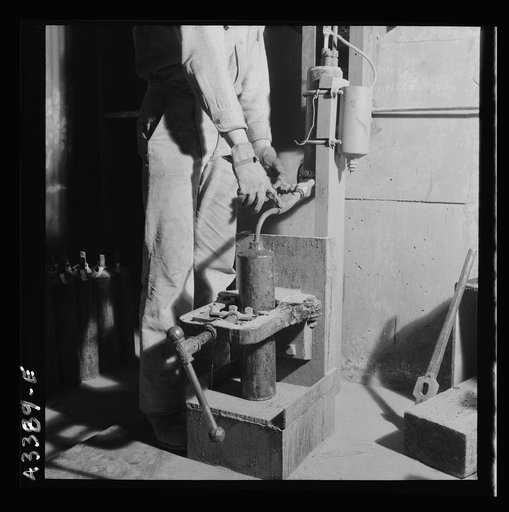 New Idria, California. Filling flasks of triple-distilled mercury at the New Idria Quicksilver Mining Company's mercury extraction plant. The flask contains seventy-six pounds of mercury