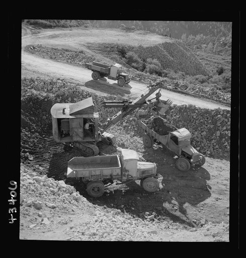 New Idria, California. Trucks, shovel, and crane used in loading cinnabar, an ore containing mercury, at an open-cut mine of the New Idria Quicksilver Mining Company's workings