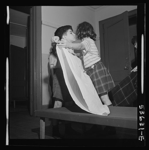 New York, New York. Children of working mothers, enrolled in a day care program at Greenwich House, tidying up after a rest period, no fresh activity being undertaken until blankets, play things or work materials have been cleaned away. They learn to feel individual responsibility for leaving things