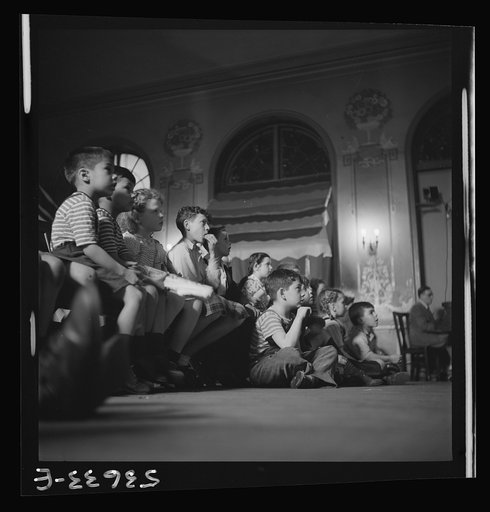 New York, New York. Children engrossed by a play put on by their playmates at Greenwich House where they spend their after-school and Saturday hours while their mothers work