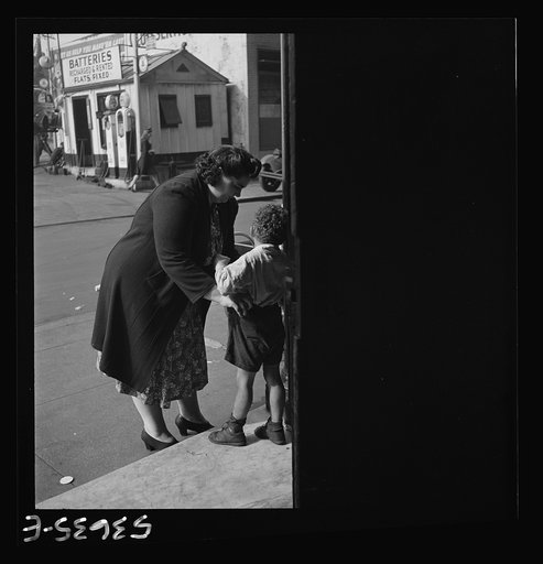 New York, New York. A small boy who receives day care at Greenwich House while his mother works being called for at the end of the day