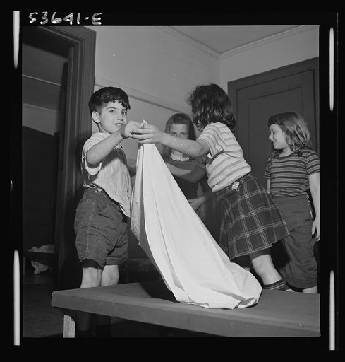 New York, New York. Children of working mothers who receive day care with educational recreation and rest at Greenwich House, tidying up after a rest period. No fresh activity is undertaken until things are cleared away