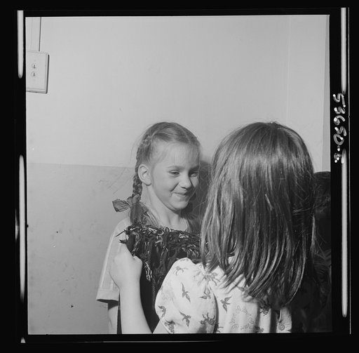 New York, New York. Two little girls folding a blanket after a rest period at Greenwich House where they receive day care while their mothers work. They enjoy work in clay, games, etc. as well as rest at this neighborhood center
