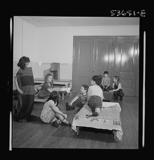New York, New York. Children putting on their shoes after a rest period at Greenwich House where they receive day care while their mothers work