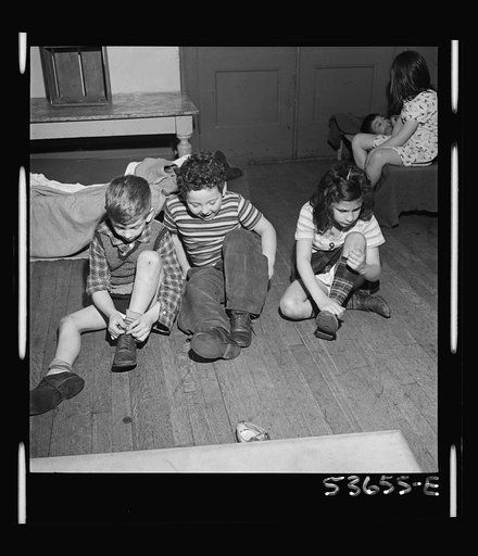 New York, New York. Children of the nursery school group at Greenwich House putting on their shoes after a rest period which is a part of the educational recreation program offered by this neighborhood center for working mothers' children