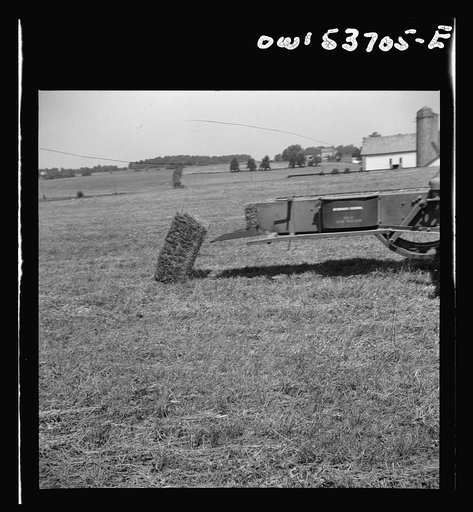 Untitled photo, possibly related to: Dresher, Pennsylvania. Making adjustments on a hay baling machine