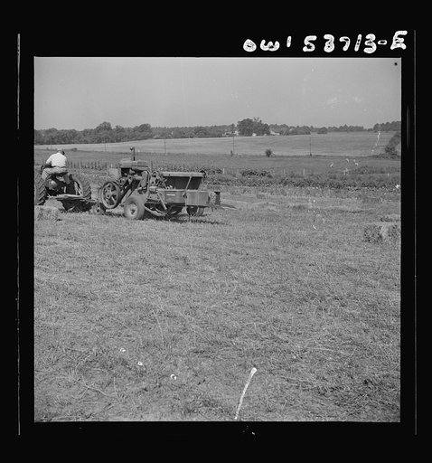 Untitled photo, possibly related to: Dresher, Pennsylvania. Making adjustments on a hay baling machine