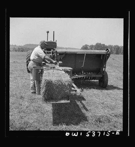 Dresher, Pennsylvania. Making adjustments on a hay baling machine
