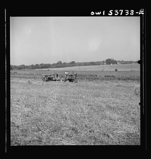 Untitled photo, possibly related to: Dresher, Pennsylvania. Detail of baling machine showing hay being picked up at the Spring Run Farm