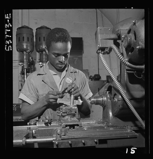 NYA (National Youth Administration) work center, Brooklyn, New York. A Negro bench-lathe worker, who is receiving training in machine shop practice, gauging a screw just removed from the collet