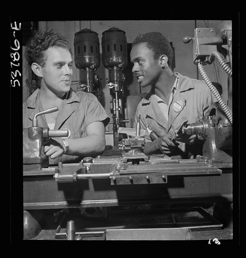 NYA (National Youth Administration) work center, Brooklyn, New York. Two bench-lathe workers, white and Negro, who are receiving training in machine shop practice, removing burrs from special taper head screws