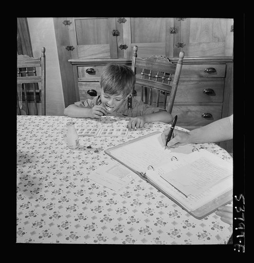 East Montpelier, Vermont. Richard, age five, son of the farmer Charles Ormsbee, has his own war project; he has agreed to lick all the savings stamps for the family