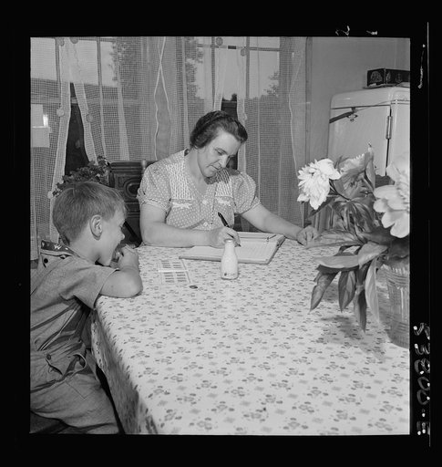 East Montpelier, Vermont. Richard, age five, son of Charles Ormsbee, shown with his mother, is licking savings stamps, a self-selected war project. All his family contribute in special ways to the war effort