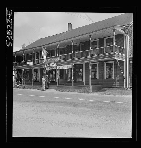 West Danville, Vermont. The two-story porch-framed general store belonging to G. S. Hastings showing the post office sign above the steps and a flag flying over the entrance