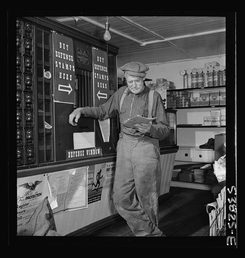 West Danville, Vermont. A farmer reading his mail at the post office in G. S. Hastings's general store