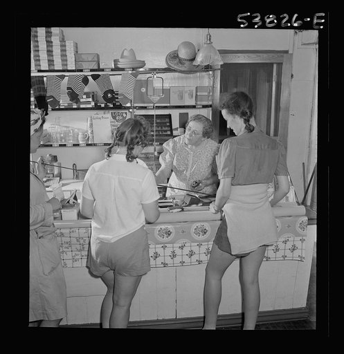 West Danville, Vermont. Girls from Saint Johnsbury where they are spending a weekend on Joe's Pond, looking over fishing tackle in G. S. Hastings's general store