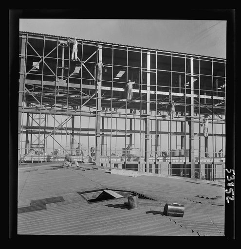 Las Vegas, Nevada. Painters at work seventy feet above ground on the gigantic construction of the Basic Magnesium Incorporated plant in the southern Nevada desert. Other workmen can be seen laying reinforcing steel for the concrete floor several stories below
