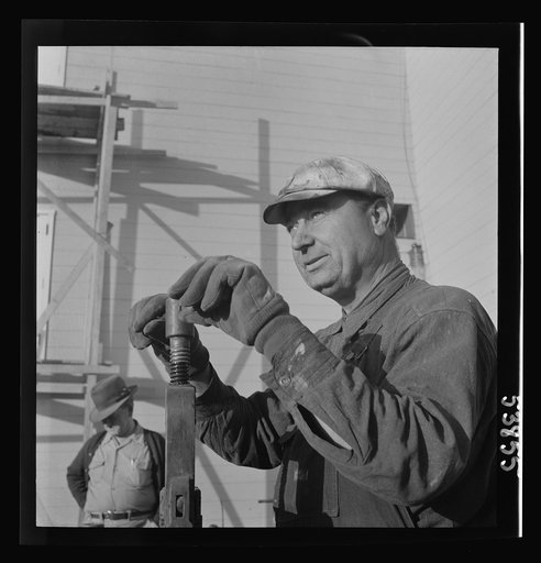 Las Vegas, Nevada. One of the construction workers at the Basic Magnesium Incorporated plant, working at the pipe vise. He is working on a building near the peat storage building near which he is standing