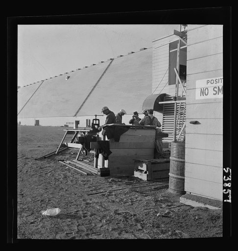 Las Vegas, Nevada. Pipe fitters at work alongside of one of the 540-foot peat storage buildings at the Basic Magnesium Incorporated plant in the southern Nevada desert