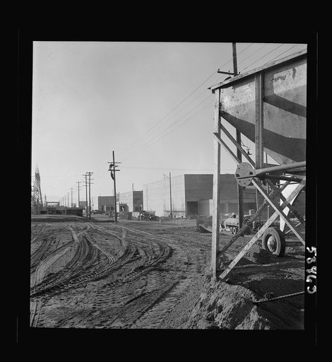 Las Vegas, Nevada. A view of the plant of Basic Magnesium Incorporated, showing unfinished roads, power lines, telephone lines on which two men are working, and buildings during an early stage of construction