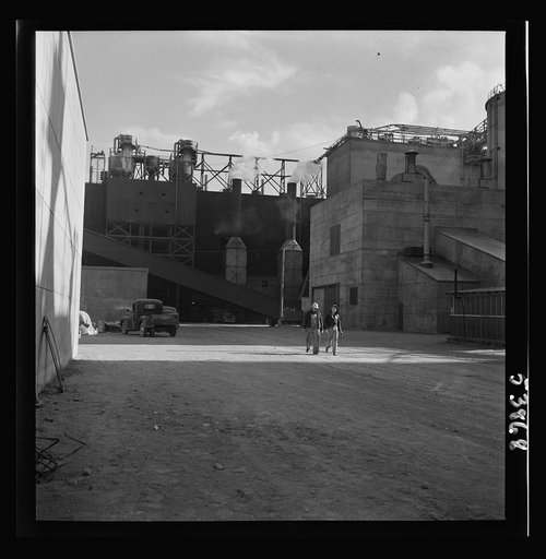 Las Vegas, Nevada. A rear view of some of the structures of the Basic Magnesium Incorporated plant, showing part of the completed buildings already being used for the production of the lightest of all metals for use in aircraft and other wartime manufacturing. Two workmen are walking in the foregrou