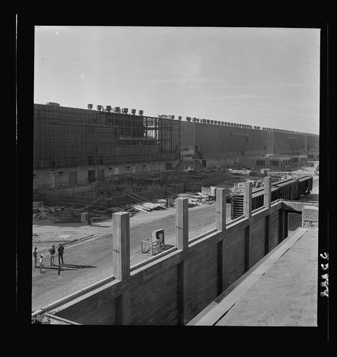 Las Vegas, Nevada. Two series of buildings and a road between, filled with construction materials, on the grounds of the huge Basic Magnesium Incorporated plant in the southern Nevada desert