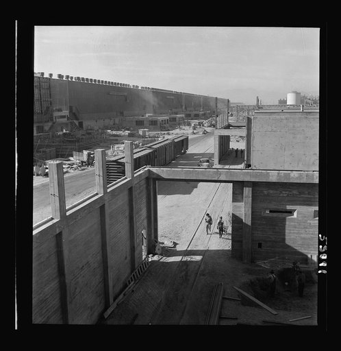 Las Vegas, Nevada. Workmen, trucks, railroad boxcars, tool sheds, and many buildings during an early construction period of the Basic Magnesium Incorporated plant in the southern Nevada desert