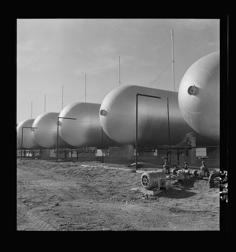Las Vegas, Nevada. Like a row of dirigible balloons, the propane gas storage tanks rest upon the floor of the southern Nevada desert at Basic Magnesium's giant plant, where magnesium is produced