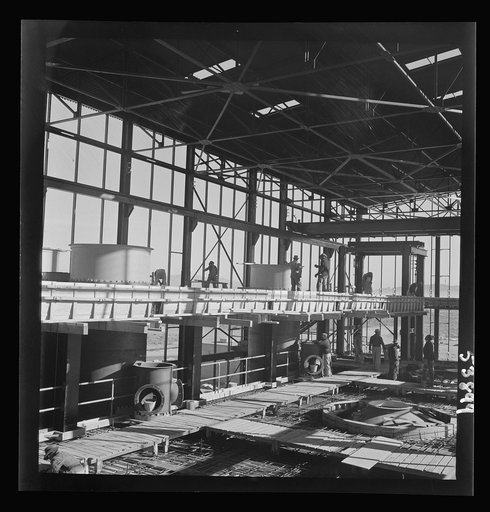 Untitled photo, possibly related to: Las Vegas, Nevada. A construction scene at the Basic Magnesium Incorporated plant in the southern Nevada desert, showing workmen engaged in the steel structure of one of the chlorination plants