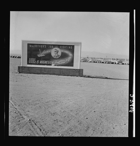 Untitled photo, possibly related to: Las Vegas, Nevada. Billboards on the grounds of the gigantic plant of Basic Magnesium Incorporated, one of which shows tracer bullets and reads "MacArthur's job is fighting. OURS is magnesium"