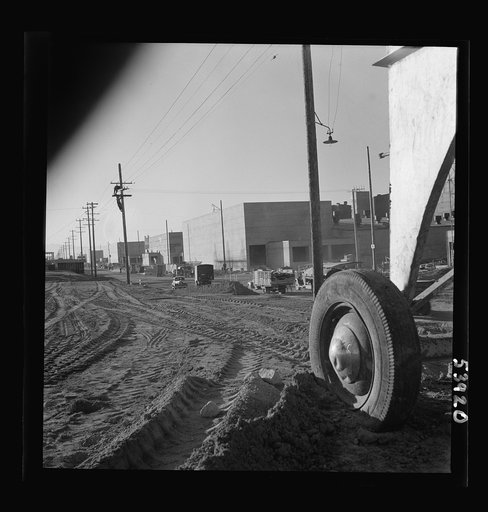 Untitled photo, possibly related to: Las Vegas, Nevada. A view of the plant of Basic Magnesium Incorporated, showing unfinished roads, power lines, telephone lines on which two men are working, and buildings during an early stage of construction