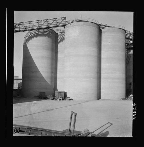 Untitled photo, possibly related to: Las Vegas, Nevada. Giant silos, eighty-four feet high, for the storage of ore for the manufacture of magnesium at the Basic Magnesium Incorporated plant in the southern Nevada desert. A peat storage building can be seen at the left