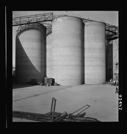Untitled photo, possibly related to: Las Vegas, Nevada. Giant silos, eighty-four feet high, for the storage of ore for the manufacture of magnesium at the Basic Magnesium Incorporated plant in the southern Nevada desert. A peat storage building can be seen at the left