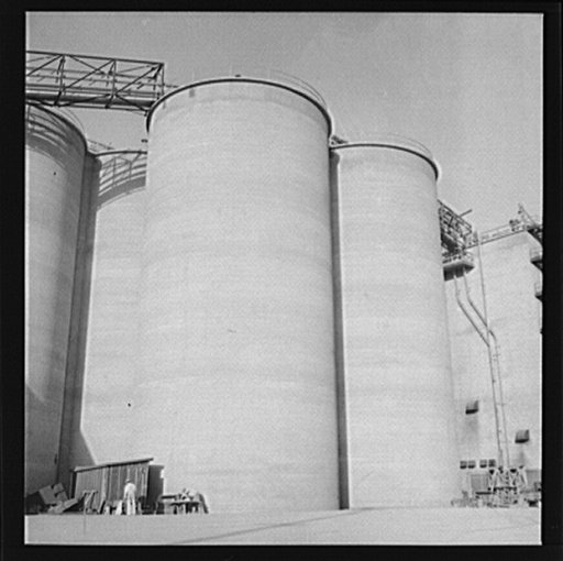 Untitled photo, possibly related to: Las Vegas, Nevada. Giant silos, eighty-four feet high, for the storage of ore for the manufacture of magnesium at the Basic Magnesium Incorporated plant in the southern Nevada desert. A peat storage building can be seen at the left