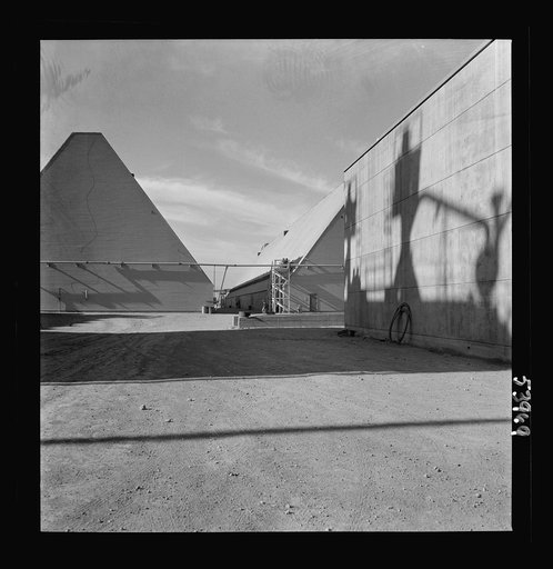 Untitled photo, possibly related to: Las Vegas, Nevada. Peat storage buildings, silos for the storage of ore, and other structures of the Basic Magnesium Incorporated plant in the southern Nevada desert