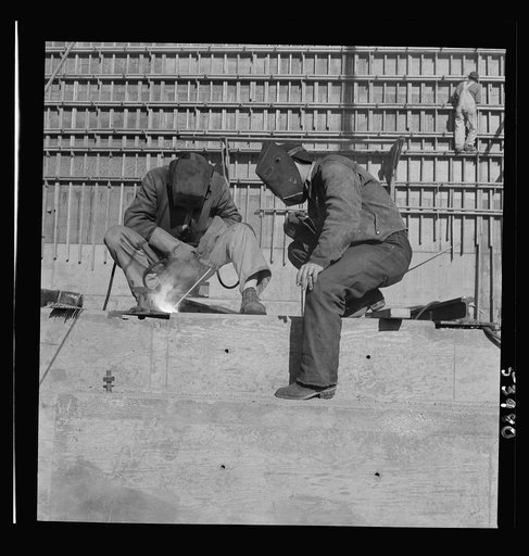 Untitled photo, possibly related to: Las Vegas, Nevada. Helmeted welders busy in their part in the completion of the Basic Magnesium plant in the southern Nevada desert, which will turn out great quantities of this lightest of all metals for aircraft and tracer bullet manufacturers