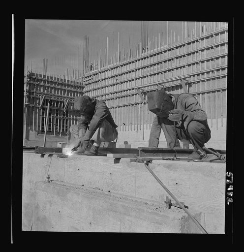 Untitled photo, possibly related to: Las Vegas, Nevada. Helmeted welders busy in their part in the completion of the Basic Magnesium plant in the southern Nevada desert, which will turn out great quantities of this lightest of all metals for aircraft and tracer bullet manufacturers