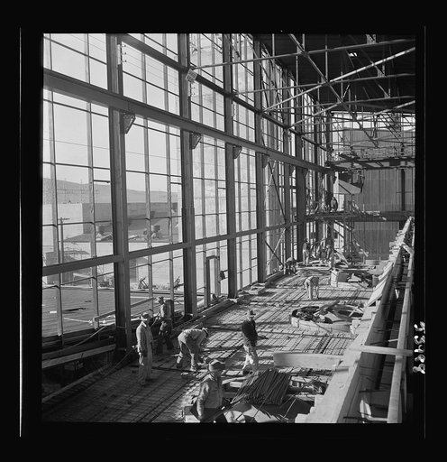 Untitled photo, possibly related to: Las Vegas, Nevada. Workmen busy with woodwork inside the steel structure of one of the buildings of the Basic Magnesium Incorporated plant. Much of the plant can be seen in the background, and beyond it loom high mountains