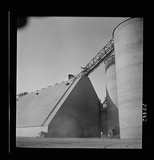 Untitled photo, possibly related to: Las Vegas, Nevada. Giant silos, eighty-four feet high, for the storage of ore for the manufacture of magnesium at the Basic Magnesium Incorporated plant in the southern Nevada desert. A peat storage building can be seen at the left
