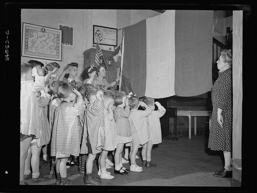 New York, New York. June 6, 1944. Preschool children at L'Ecole maternelle francais on D-day saluting the French flag