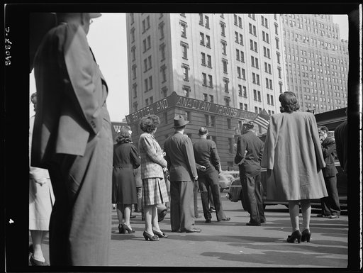 New York, New York. People watching the electrical news sign on the Times building at Times Square