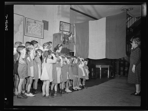 New York, New York. June 6, 1944. Preschool age children at L'Ecole maternelle francaise on D-day saluting the French flag