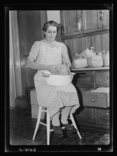 Mrs. Albert Yaeger] storing home-dried [apples or corn] in sugar sacks