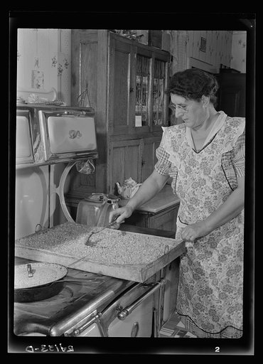 Mrs. Harry Mercer stirring a mixture of corn, cream, sugar and salt on the dryer. The corn will remain here for two to three days